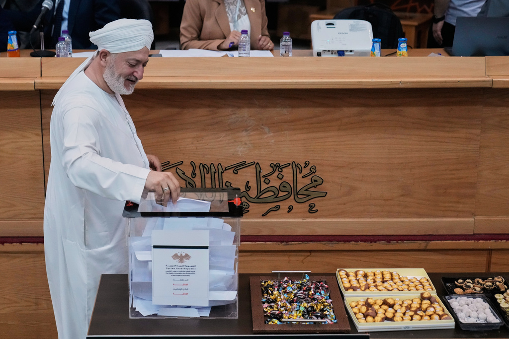 A Syrian cleric man from the electoral college member casts his vote during the parliamentary elections at Latakia's Governor ballot station, in the costal city of Latakia, Syria, Sunday, Oct. 5, 2025. (AP Photo/Hussein Malla)
