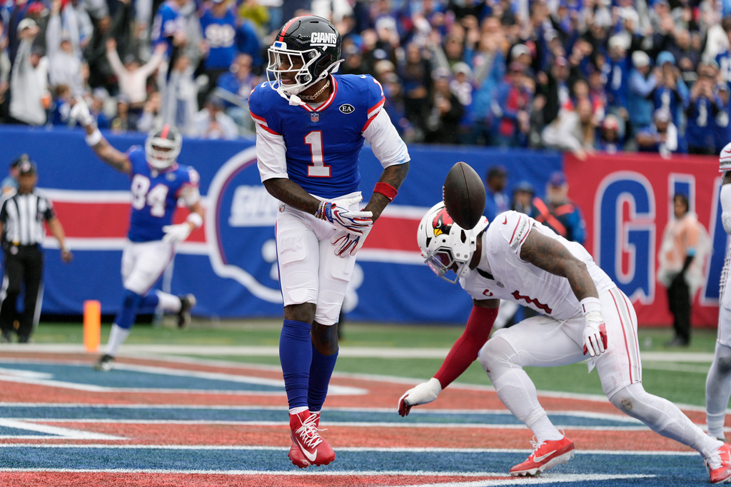 New York Giants wide receiver Malik Nabers (1) celebrates a touchdown catch against Arizona Cardinals linebacker Mack Wilson Sr., right, during an NFL football game, in East Rutherford, N.J., Sunday, Oct. 4, 2026. (AP Photo/Seth Wenig)