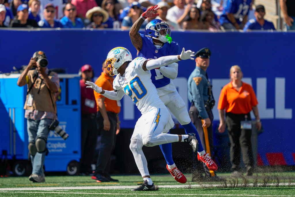 New York Giants wide receiver Malik Nabers (1) leaps for a pass against Los Angeles Chargers cornerback Cam Hart (20) during the second quarter of an NFL football game, Sunday, Sept. 28, 2025, in East Rutherford, N.J. (AP Photo/Yuki Iwamura)