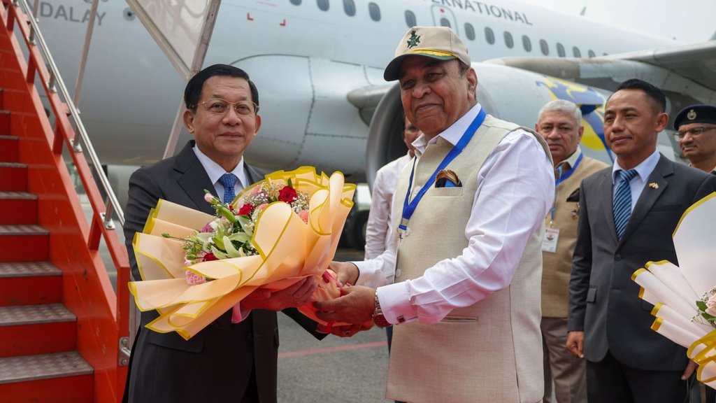 In this photo provided by Myanmar Military True News Information Team on Saturday, May 30, 2026, Myanmar President Min Aung Hlaing, left, receives flowers from Bihar State Governor and retired Lt- General Syed Ata Hasnian, right, upon arrival at Gaya airport, India on May 30. (Myanmar Military True News Information Team via AP Photo)