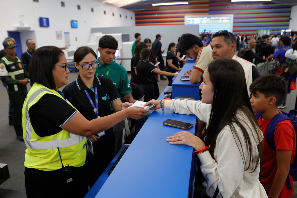 Passengers check in at Simon Bolivar International Airport as it reopens to commercial flights two months after closing due to the earthquake in Maiquetia, Venezuela, Tuesday, Sept. 1, 2026. (AP Photo/Pedro Mattey)