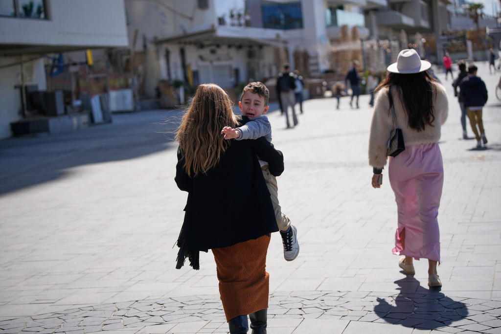 People rush to take shelter as warning sirens sound following missile fired towards Israel, in Tel Aviv, Israel, Saturday, Feb. 28, 2026. (AP Photo/Ohad Zwigenberg)