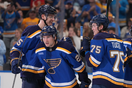 St. Louis Blues' Jimmy Snuggerud (21) is congratulated by Colton Parayko, left, and Tyler Tucker (75) after scoring during the second period of an NHL hockey game against the Dallas Stars Saturday, Oct. 18, 2025, in St. Louis. (AP Photo/Jeff Roberson) St. Louis Blues' Jimmy Snuggerud (21) is congratulated by Colton Parayko, left, and Tyler Tucker (75) after scoring during the second period of an NHL hockey game against the Dallas Stars Saturday, Oct. 18, 2025, in St. Louis. (AP Photo/Jeff Roberson)