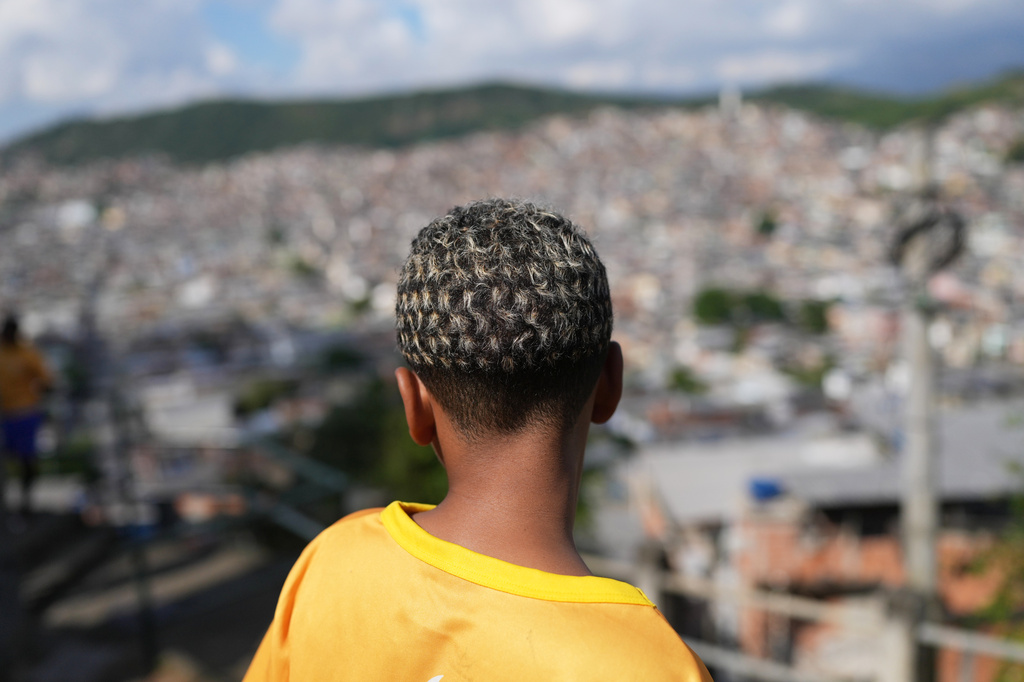 A youth whose hair is decoratively bleached stands in the Complexo da Penha of Rio de Janeiro, after attending soccer training by the Street Child United Brazil social project, Wednesday, June 3, 2026. (AP Photo/Silvia Izquierdo)