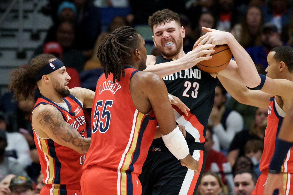 Portland Trail Blazers center Donovan Clingan (23) battles for the ball with New Orleans Pelicans guard Jose Alvarado, left, and forward Kevon Looney (55) during the first half of an NBA basketball game in New Orleans, Friday, Jan. 2, 2026. (AP Photo/Matthew Hinton)