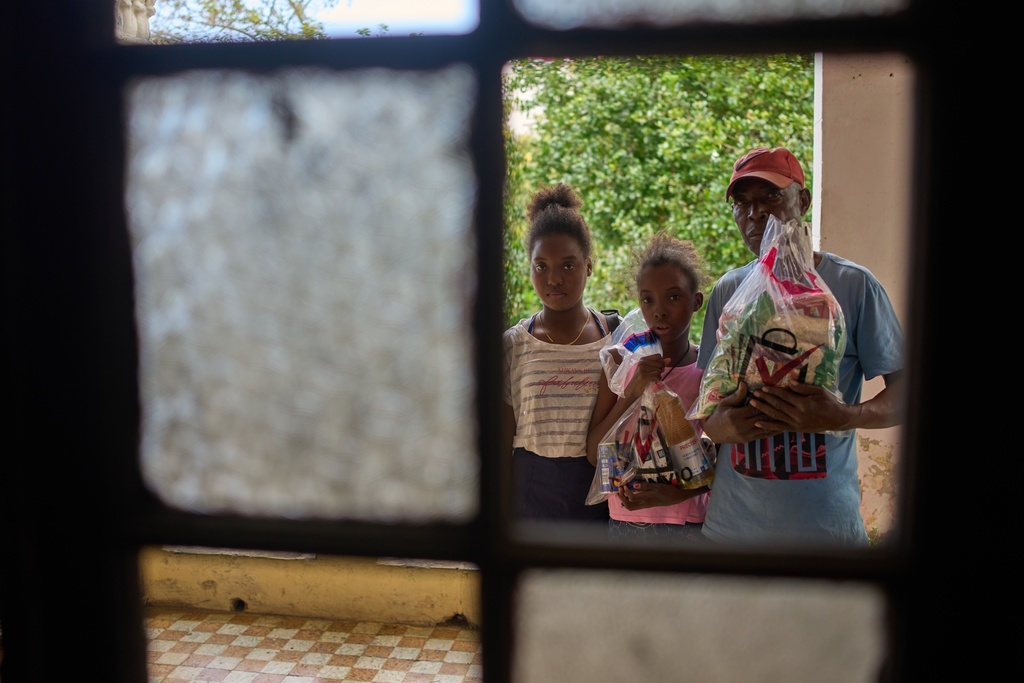 Guillermo Beltran, a recipient of Mexican humanitarian assistance, poses for a photo with his daughters Chanely, left and Chanela, holding his donated items at their home in Havana, Cuba, Thursday, Feb. 19, 2026. (AP Photo/Ramon Espinosa)