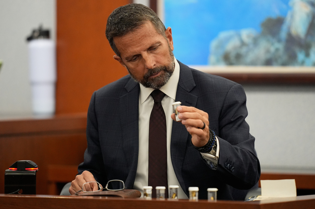 Dean O'Kelley, a Las Vegas police officer at the scene of shooting, holds shell casings as he testifies during the murder trial of Duane "Keffe D" Davis related to the 1996 killing of rapper Tupac Shakur, at Clark County District Court Regional Justice Center in Las Vegas, on Tuesday, Aug. 18, 2026. (AP Photo/John Locher, Pool)