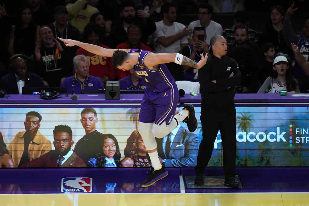 Los Angeles Lakers guard Luka Doncic celebrates his three-point basket past Los Angeles Clippers head coach Tyronn Lue during the first half of an NBA Cup basketball game Tuesday, Nov. 25, 2025, in Los Angeles. (AP Photo/Jae C. Hong)