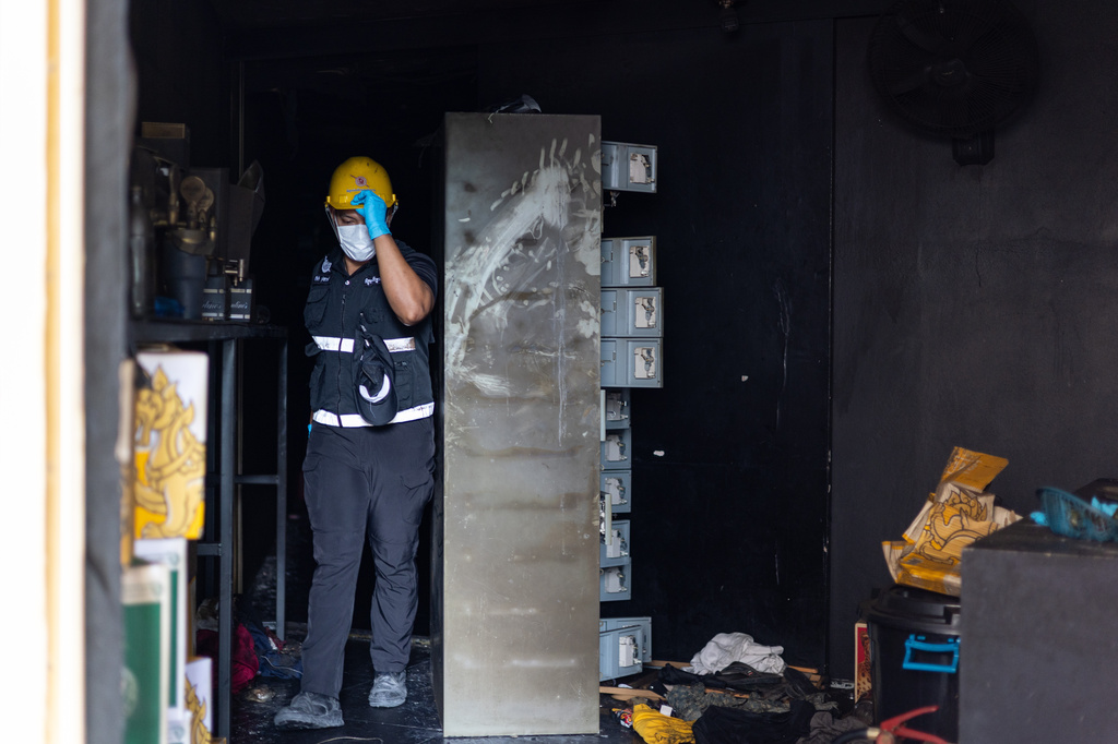 An official with the Thai Forensic Police examines the back exit of the Rong Beer Na Ladprao bar in Bangkok, Thailand on Tuesday, July 14, 2026. (AP Photo/Anton L. Delgado)