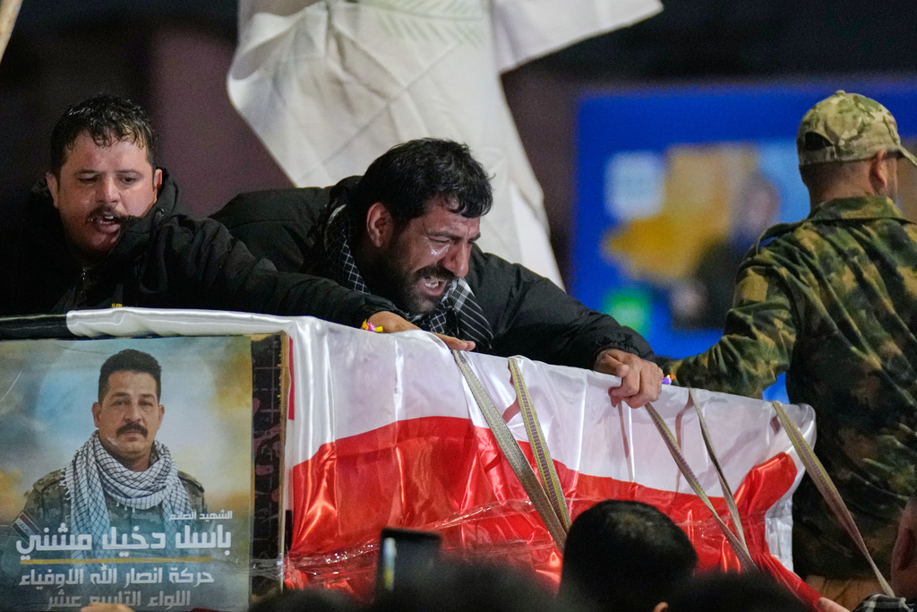 Relatives grieve in Baghdad, Iraq, on Thursday, March 12, 2026, during a funeral for members of the Popular Mobilization Forces who were killed in a U.S. airstrike in Qaim. (AP Photo/Hadi Mizban)