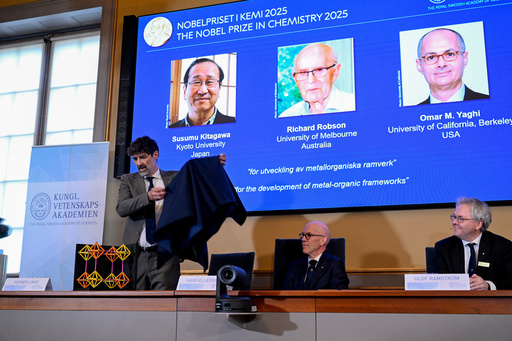 Chair of the Nobel Committee for Chemistry Heiner Linke makes a demonstration, next to Secretary General of the Swedish Academy of Sciences Hans Ellegren, and Member of the Nobel Committee for Chemistry Olof Ramstrom, right, after they announce Susumu Kitagawa, Richard Robson and Omar Yaghi, on screen behind, as the recipients the Nobel Prize in Chemistry, at the Nobel Assembly of the Karolinska Institutet, in Stockholm, Sweden, Wednesday, Oct. 8, 2025. (Fredrik Sandberg/TT News Agency via AP) Chair of the Nobel Committee for Chemistry Heiner Linke makes a demonstration, next to Secretary General of the Swedish Academy of Sciences Hans Ellegren, and Member of the Nobel Committee for Chemistry Olof Ramstrom, right, after they announce Susumu Kitagawa, Richard Robson and Omar Yaghi, on screen behind, as the recipients the Nobel Prize in Chemistry, at the Nobel Assembly of the Karolinska Institutet, in Stockholm, Sweden, Wednesday, Oct. 8, 2025. (Fredrik Sandberg/TT News Agency via AP)