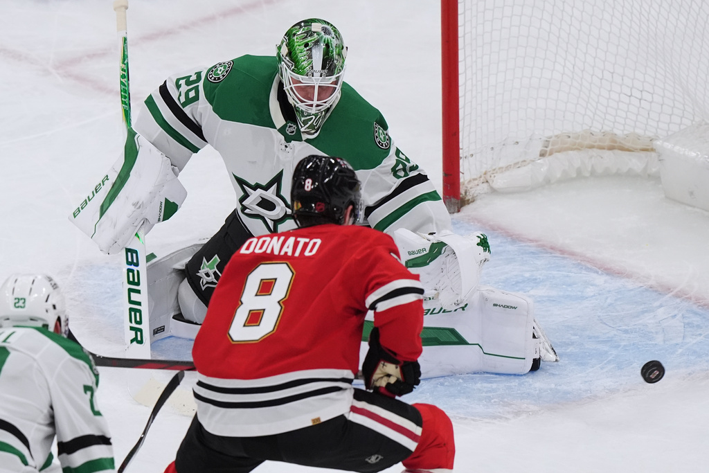 Dallas Stars goaltender Jake Oettinger, top, saves a shot by Chicago Blackhawks center Ryan Donato during the second period of an NHL hockey game in Chicago, Thursday, Jan. 1, 2026. (AP Photo/Nam Y. Huh)