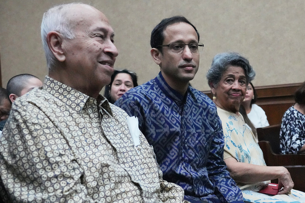 Nadiem Anwar Makarim, former Education Minister and the co-founder of Indonesia's payments platform and ride hailing company Gojek, center, who is accused of corruption in a government project to procure school laptops, is flanked by his parents Nono Anwar Makarim, left, and Atika Algadrie before the start of his trial hearing at the Corruption Court in Jakarta, Indonesia, Monday, April 20, 2026. (AP Photo/Achmad Ibrahim)