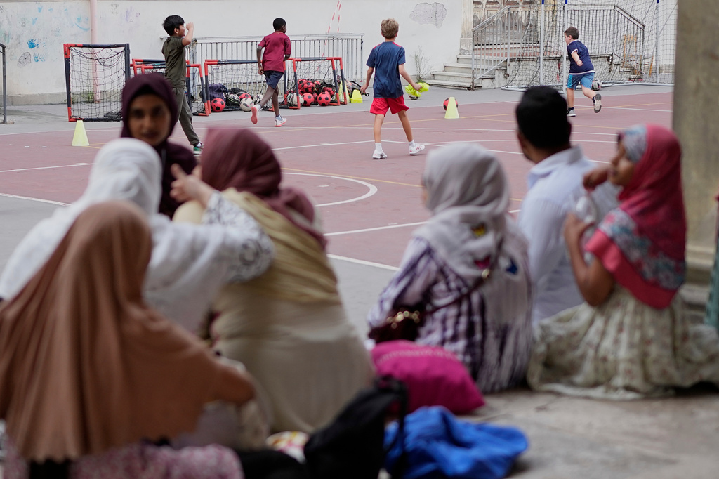 Jannatur Nayeem, 33, an Italian citizen of Bangladeshi origin, top left face to the camera, chats with other mothers as they wait for a sports lesson to end at a school in downtown Rome, Thursday, Sept. 24, 2026. (AP Photo/Alessandra Tarantino)