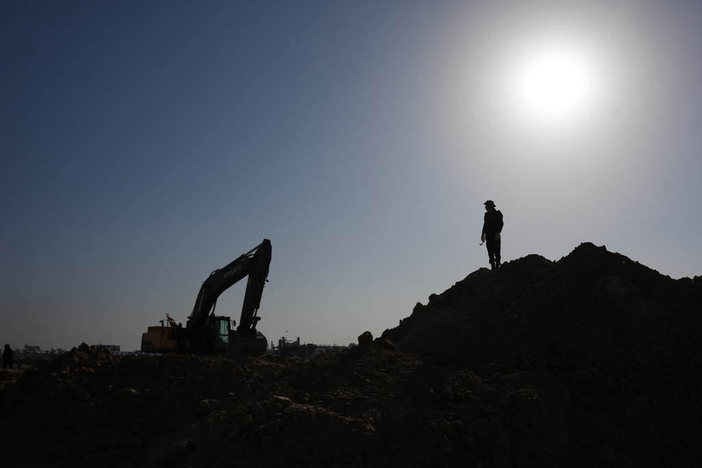 Islamic Jihad militants and Egyptian workers search for the bodies of hostages north of Nuseirat, Gaza strip, Saturday, Nov. 22, 2025. (AP Photo/Abdel Kareem Hana)