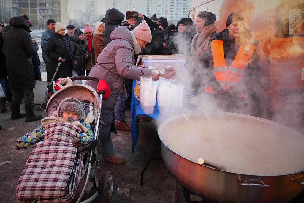 Yuliia Dolotova, 37, receives hot food at a distribution point during a power outage caused by Russia’s repeated air strikes on the country’s power grid, in Kyiv, Ukraine, Monday, Feb. 2, 2026. (AP Photo/Sergey Grits)