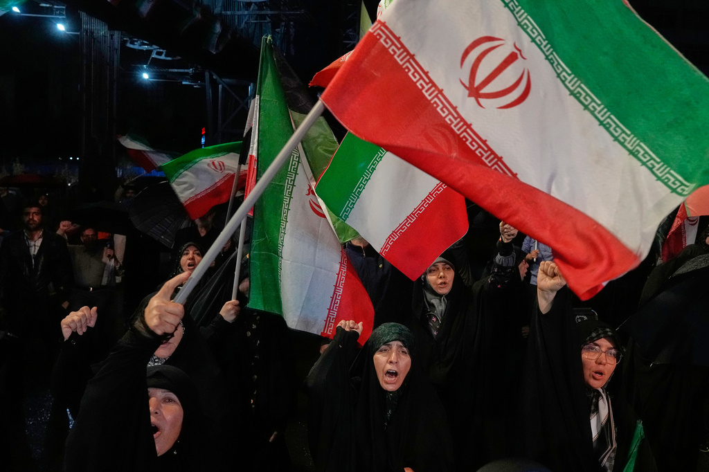 Pro-government demonstrators chant slogans as they wave Iranian flags during their gathering at a square in downtown Tehran, Iran, Tuesday, May 19, 2026. (AP Photo/Vahid Salemi)
