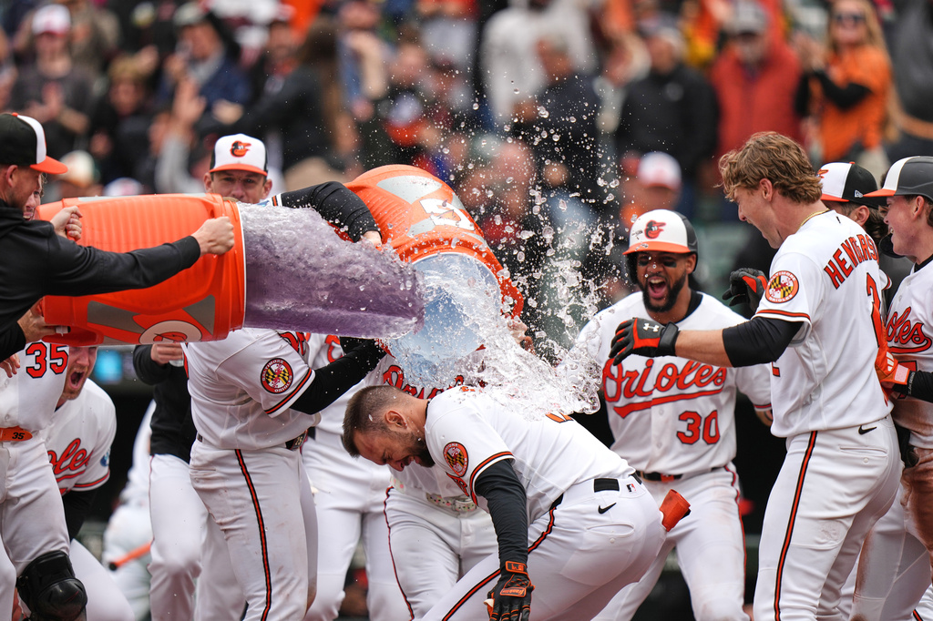 Baltimore Orioles' Colton Cowser, center front, celebrates with teammates after hitting a walkoff three-run home run during the ninth inning in the first baseball game of a doubleheader against the Detroit Tigers, Sunday, May 24, 2026, in Baltimore. (AP Photo/Stephanie Scarbrough)