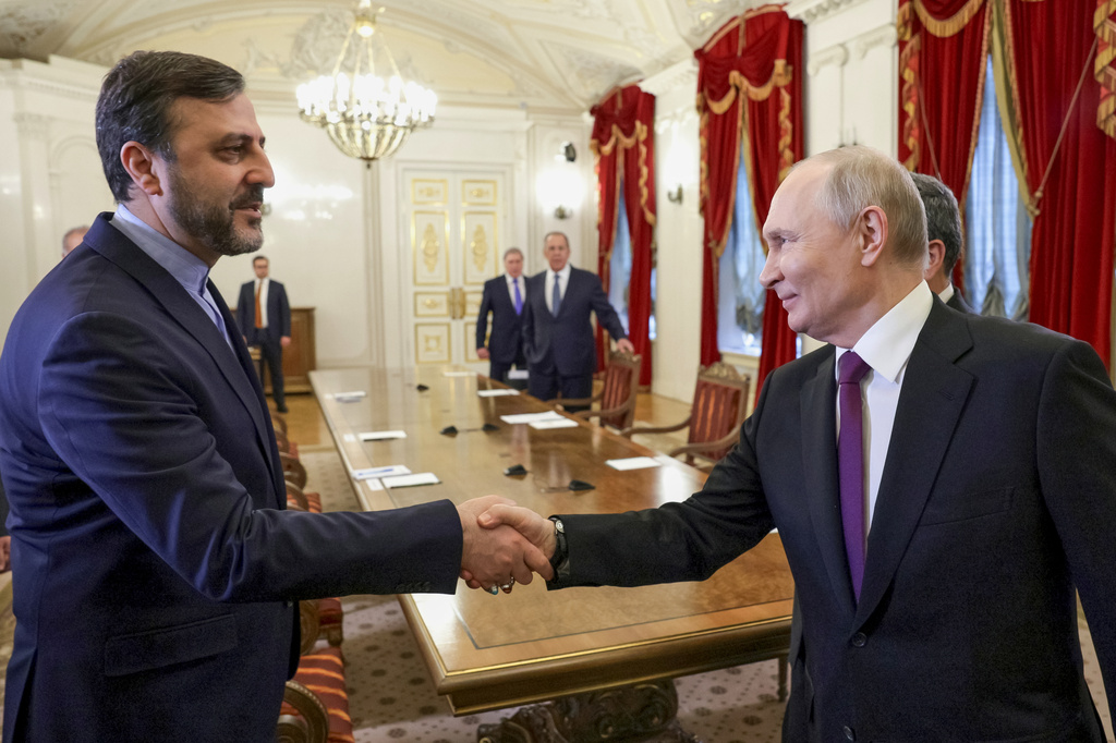 Russian President Vladimir Putin, right, shakes hands with Iranian Deputy Foreign Minister Kazem Gharibabadi, at the Boris Yeltsin Presidential Library, in St. Petersburg, Russia, Monday, April 27, 2026. (Gavriil Grigorov, Sputnik, Kremlin Pool Photo via AP)