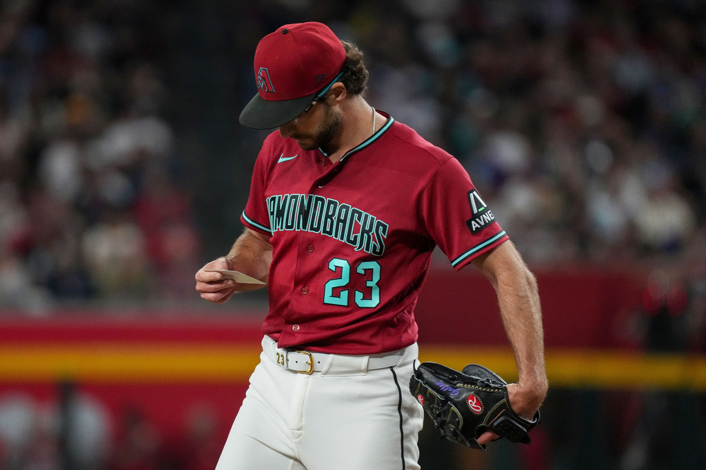 Arizona Diamondbacks pitcher Zac Gallen looks at his line up card against the Minnesota Twins during the first inning of a baseball game Saturday, June 20, 2026, in Phoenix. (AP Photo/Darryl Webb)