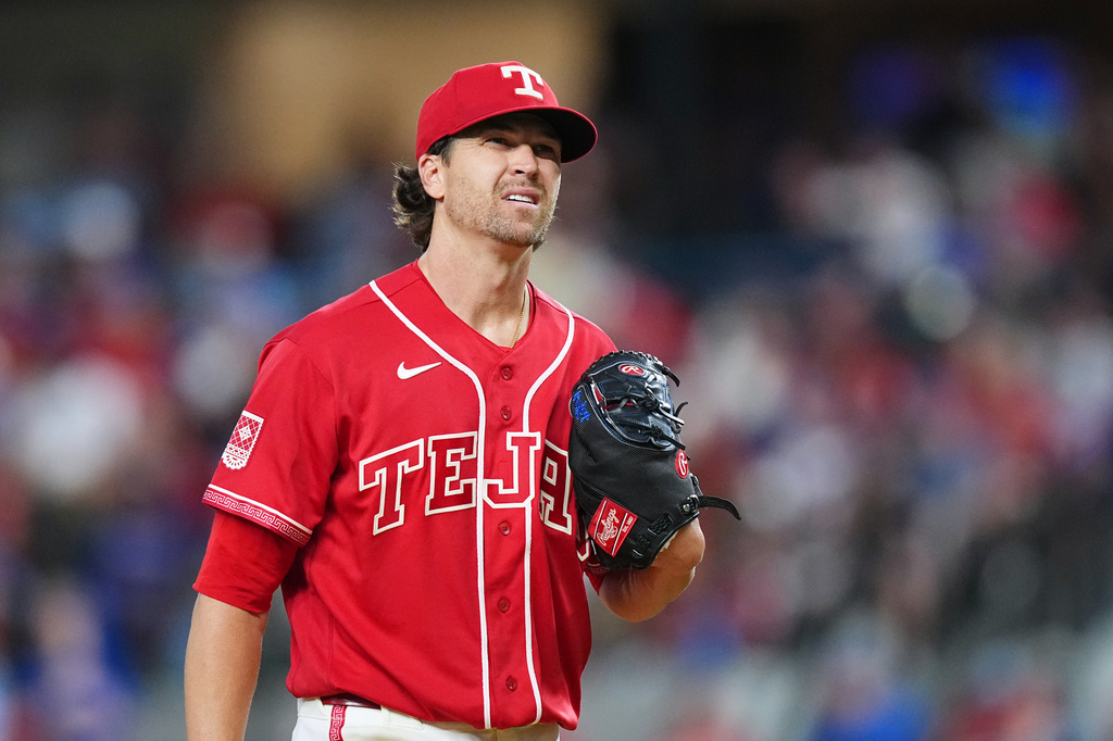 Texas Rangers starting pitcher Jacob Degrom reacts between pitches to the San Diego Padres during the first inning of a baseball game, Friday, June 19, 2026 in Arlington, Texas. (AP Photo/Julio Cortez)