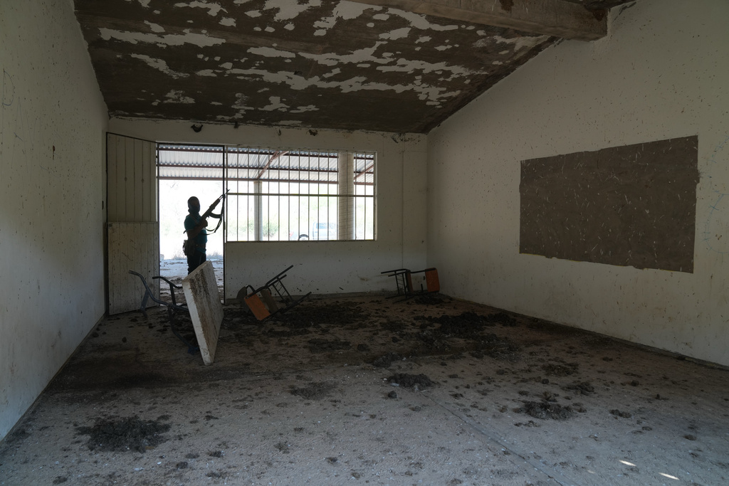 A member of a local self-defense group formed by residents in response to cartel violence guards a closed school in Guajes de Ayala, Mexico, Wednesday, March 11, 2026. (AP Photo/Marco Ugarte)