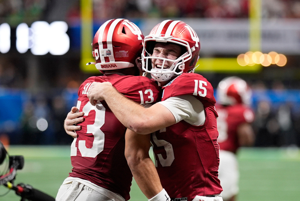 Indiana wide receiver Elijah Sarratt (13) celebrates his touchdown reception with quarterback Fernando Mendoza (15) during the second half of the Peach Bowl NCAA college football playoff semifinal, Friday, Jan. 9, 2026, in Atlanta. (AP Photo/Mike Stewart)