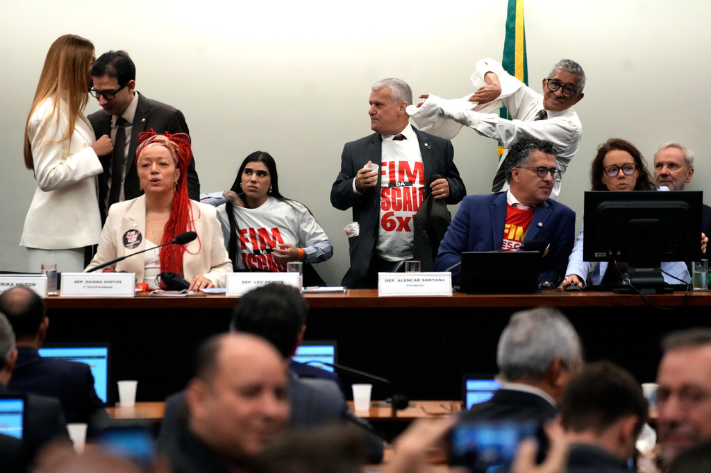Lawmakers wear T-shirts reading in Portuguese: "End the 6x1 scale" during a special committee session analyzing the proposal at the Chamber of Deputies in Brasilia, Brazil, Wednesday, May 27, 2026. (AP Photo/Eraldo Peres)
