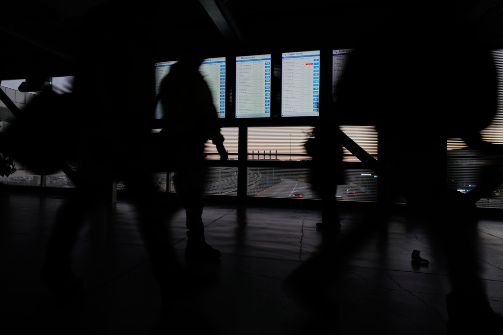 Travelers walk through the skyway leading to terminal 3 at O'Hare International Airport in Chicago, Wednesday, Nov. 12, 2025. (AP Photo/Nam Y. Huh)