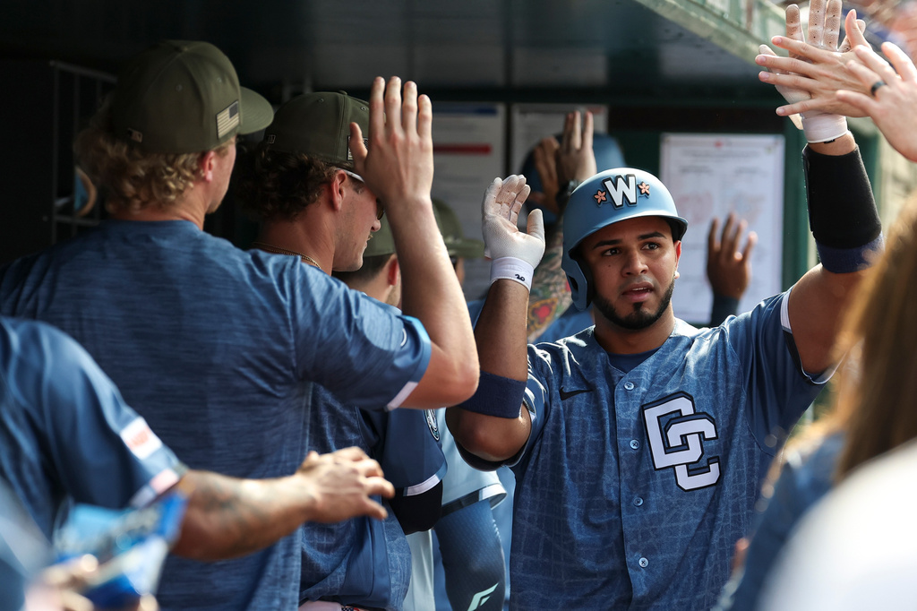 Washington Nationals' Keibert Ruiz, right, is greeted in the dugout after hitting three-run home run off Baltimore Orioles pitcher Chris Bassitt which also scored CJ Abrams and Nasim Nunez during the second inning of a baseball game, Saturday, May 16, 2026, in Washington. (AP Photo/Terrance Williams)