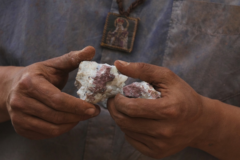 Hugo Flores analyzes a rock recently extracted from the mine in San Joaquin, Mexico, Tuesday, Aug. 19, 2025. (AP Photo/Fernando Llano)