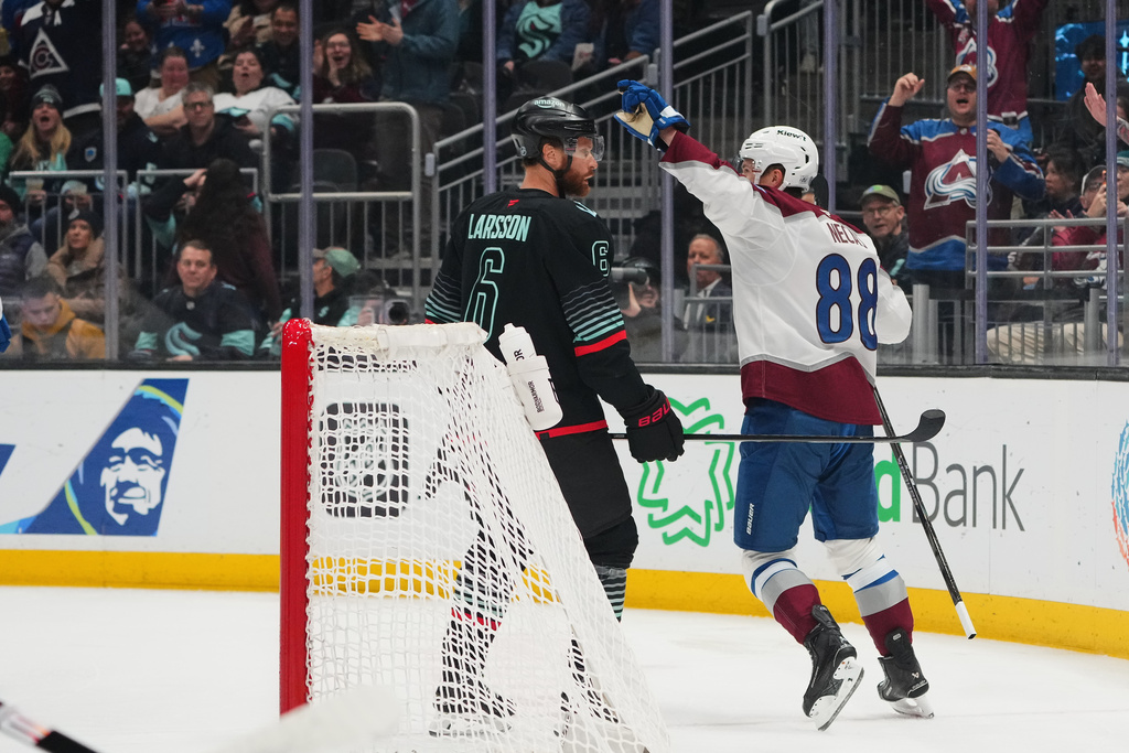 Colorado Avalanche center Martin Necas (88) reacts to scoring as Seattle Kraken defenseman Adam Larsson (6) looks on during the first period of an NHL hockey game Thursday, March 12, 2026, in Seattle. (AP Photo/Lindsey Wasson)