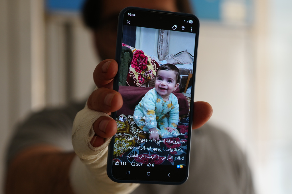 Fahd Abu Haikal, 41 displays a mobile photo of his seven month old Palestinian baby boy Sam, who was killed on Friday when Israeli soldiers fired at the vehicle carrying him and his parents in Tel Rumeida, at a hospital in the West Bank city of Hebron Saturday, June 6, 2026. (AP Photo/Mahmoud Illean)