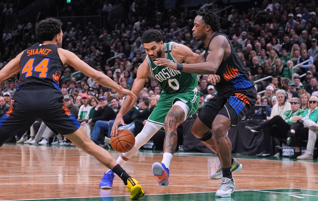 Boston Celtics' Jayson Tatum (0) is covered by New York Knicks' Og Anunoby, right, and Landry Shamet (44) on a drive to the basket during the first half of an NBA basketball game, Friday, Oct. 23, 2026, in Boston. (AP Photo/Charles Krupa)