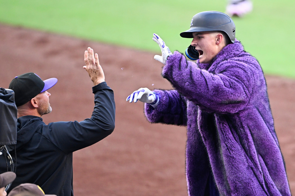 Colorado Rockies' Mickey Moniak, right, is congratulated by manager Warren Schaeffer after hitting a two-run home run during the first inning of a baseball game against the San Diego Padres Saturday, April 11, 2026, in San Diego. (AP Photo/Denis Poroy)
