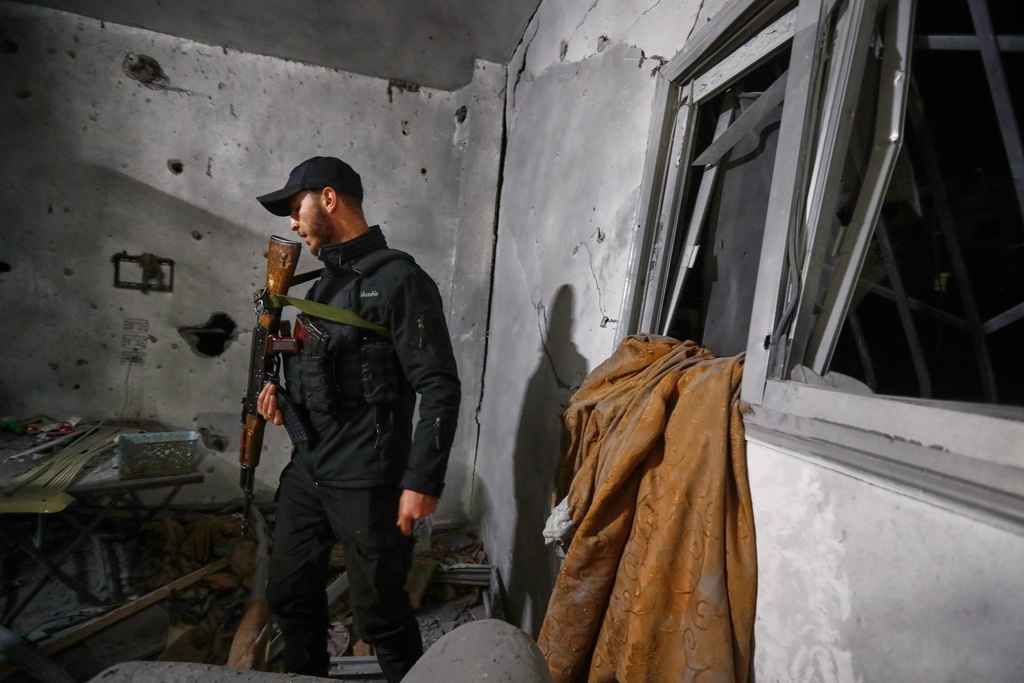 A Syrian Internal Security Forces officer inspects a home in Damascus, Syria, Friday, Nov. 14, 2025, after it was hit by rockets, according to state media. It was not immediately clear who was behind the attack. (AP Photo/Omar Sanadiki)