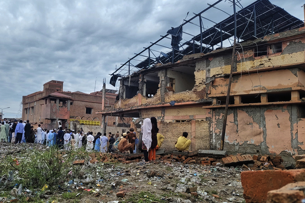 Local residents look at a damaged area of a police station after an overnight deadly bombing in the Bannu district of northwestern Pakistan, Friday, April 3, 2026. (AP Photo/Amaad Khattak)