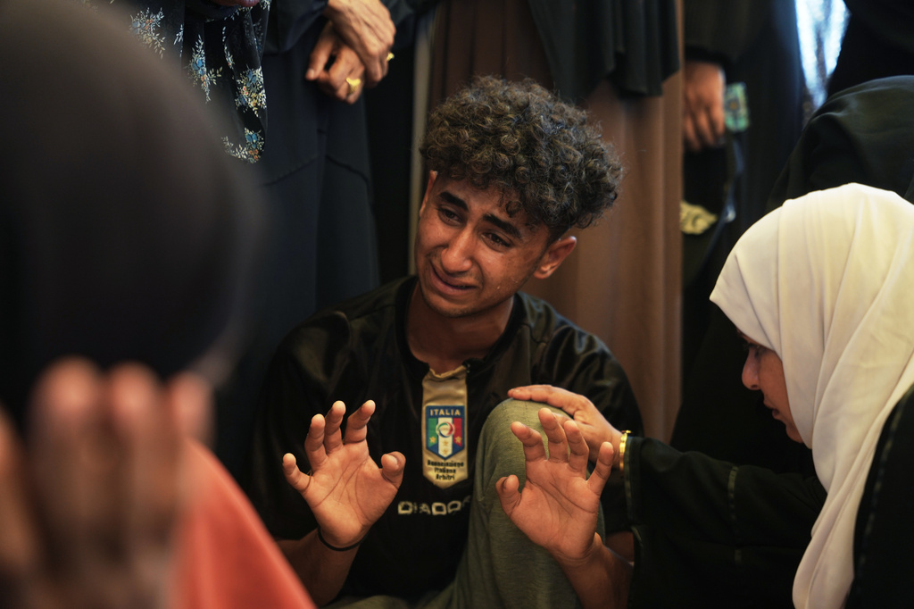 Mourners cry while they take the last look at the body of Palestinian Islam Moussa, 15, who was killed in an Israeli airstrike, during her funeral in Khan Younis, southern Gaza Strip, Saturday, June 27, 2026. (AP Photo/Abdel Kareem Hana)