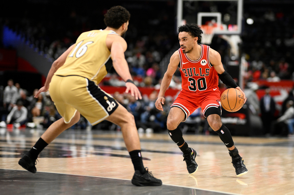 Chicago Bulls guard Tre Jones (30) dribbles against Washington Wizards forward Anthony Gill (16) during the first half of an NBA basketball game, Thursday, April 9, 2026, in Washington. (AP Photo/Nick Wass)