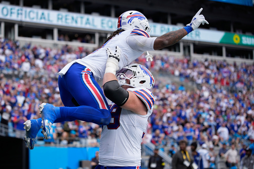 Buffalo Bills offensive tackle Spencer Brown (79) holds up Buffalo Bills running back James Cook III (4) after Cook scored a touchdown against the Carolina Panthers during the first half an NFL football game, Sunday, Oct. 26, 2025, in Charlotte, N.C. (AP Photo/Jacob Kupferman) Buffalo Bills offensive tackle Spencer Brown (79) holds up Buffalo Bills running back James Cook III (4) after Cook scored a touchdown against the Carolina Panthers during the first half an NFL football game, Sunday, Oct. 26, 2025, in Charlotte, N.C. (AP Photo/Jacob Kupferman)