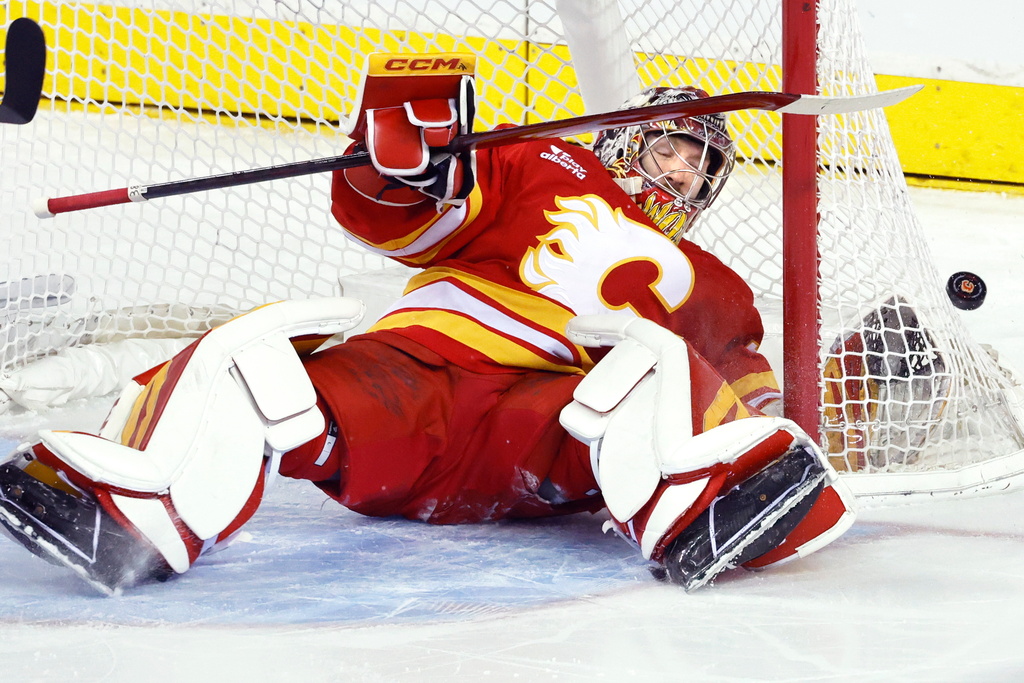 Calgary Flames goalie Dustin Wolf makes a save against the Anaheim Ducks during first-period NHL hockey game action in Calgary, Alberta, Sunday, Jan. 25, 2026. (Larry MacDougal/The Canadian Press via AP)