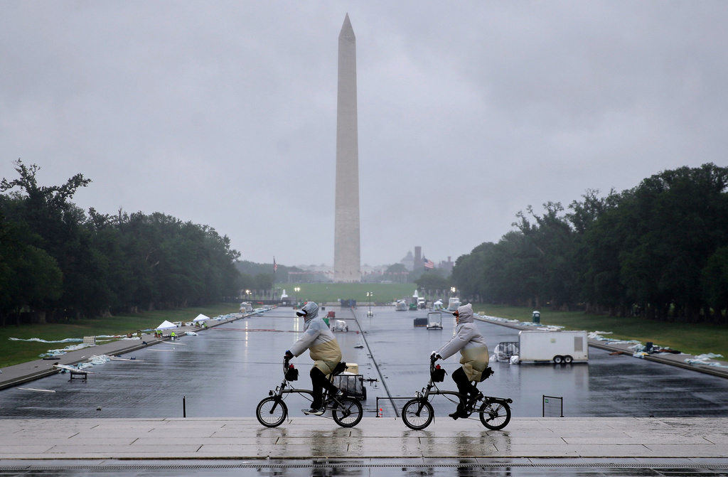 Tourists ride bicycles near the Lincoln Memorial, as a blue protective coating as part of a renovation project to the Lincoln Memorial Reflecting Pool, is seen in the background, Friday, May 22, 2026, in Washington. The Washington Monument stands in he background. (AP Photo/Rahmat Gul)