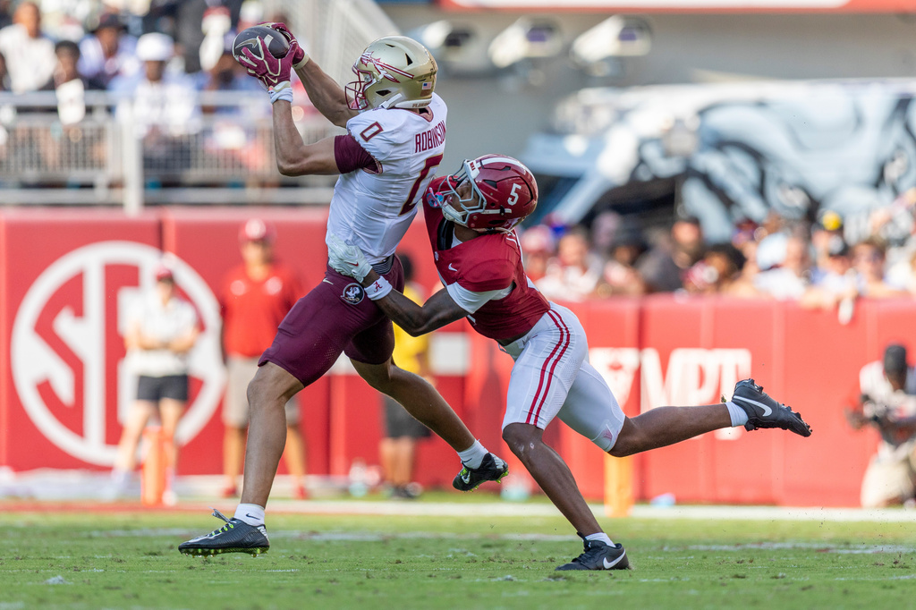 Florida State wide receiver Duce Robinson (0) grabs a pass with defense from Alabama defensive back Dijon Lee Jr. (5) during the first half of an NCAA college football game Saturday, Sept. 19, 2026, in Tuscaloosa, Ala. (AP Photo/Vasha Hunt)