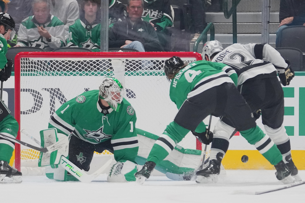 Dallas Stars goaltender Casey Desmith (1) makes a kick save as Los Angeles Kings left wing Trevor Moore (12) attacks during the first period of an NHL hockey game Monday, Dec. 15, 2025, in Dallas. (AP Photo/Julio Cortez)