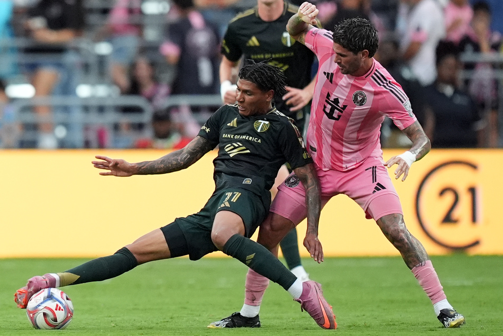 Portland Timbers forward Antony Alves Santos (11) comes under pressure from Inter Miami midfielder Rodrigo de Paul (7) during the first half of an MLS soccer match, Sunday, May 17, 2026, in Miami. (AP Photo/Rebecca Blackwell)