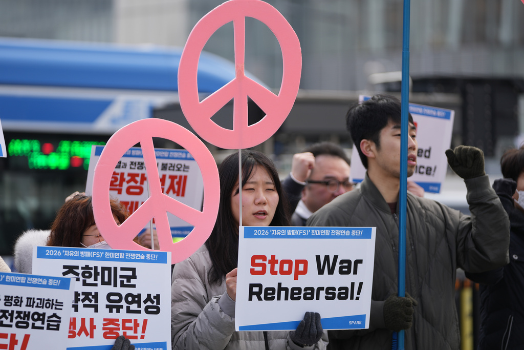 Protesters hold signs to oppose the joint military exercise between the U.S. and South Korea, near the U.S. Embassy in Seoul, South Korea, Monday, March 9, 2026. (AP Photo/Lee Jin-man)