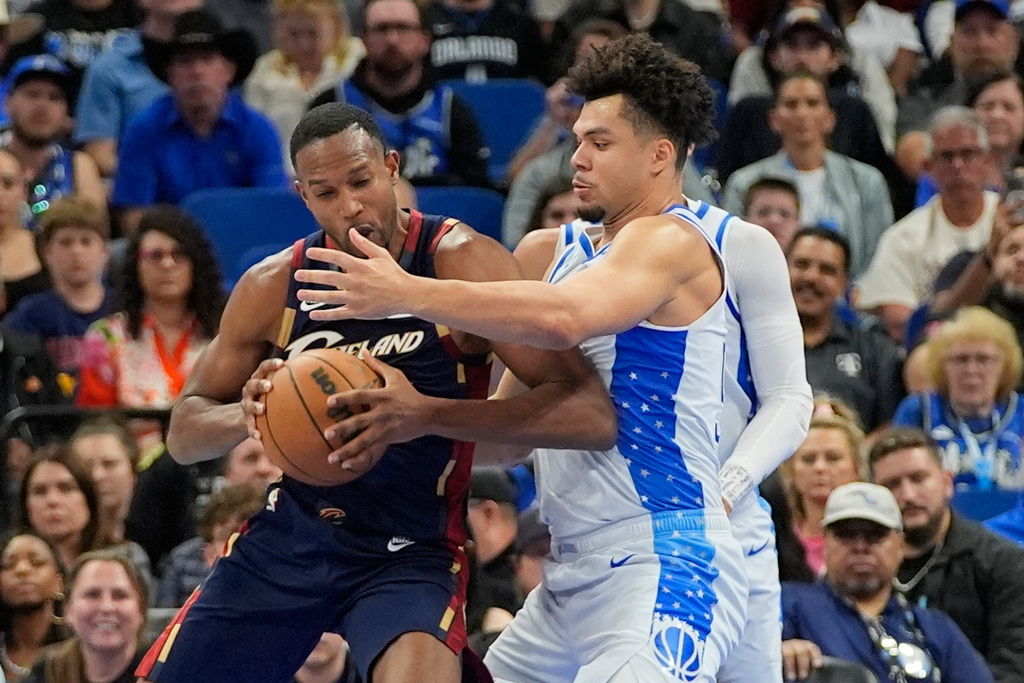 Cleveland Cavaliers center Evan Mobley, left, tries to get to the basket against Orlando Magic forward Noah Penda during the first half of an NBA basketball game, Wednesday, March 11, 2026, in Orlando, Fla. (AP Photo/John Raoux)