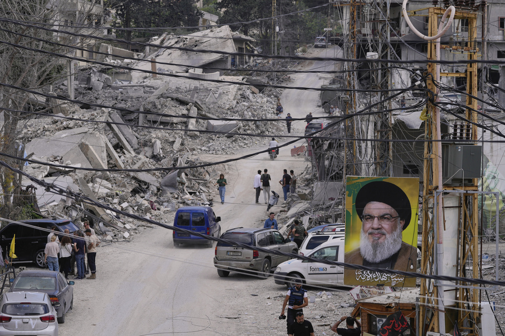 People who return to their village following the announcement of an initial ceasefire agreement between the United States and Iran, gather with journalists at a destroyed street in Beer al-Salassel, south Lebanon, Monday, June 15, 2026. (AP Photo/Mohammed Zaatari)