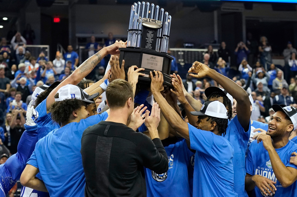 FILE - Duke players hold up the trophy after Duke's win over Virginia in an NCAA college basketball game for the championship of the men's Atlantic Coast Conference Tournament in Greensboro, N.C., March 11, 2023. (AP Photo/Chuck Burton, File)
