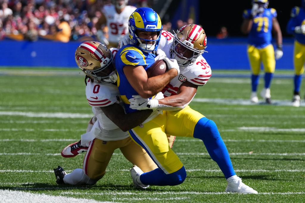 Los Angeles Rams wide receiver Puka Nacua is tackled by San Francisco 49ers cornerback Renardo Green and safety Marques Sigle during the first half of an NFL football game, Friday, Sept. 11, 2026, in Melbourne, Australia. (AP Photo/Scott Barbour)